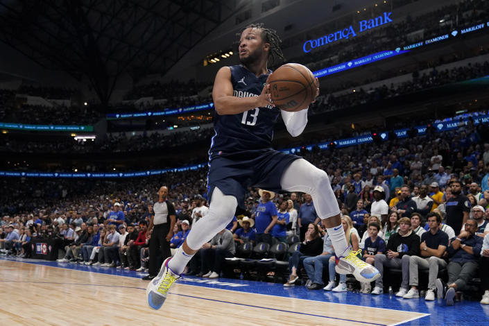 Dallas Mavericks guard Jalen Brunson (13) saves the ball from going out of bounds during the second half against the Golden State Warriors in Game 3 of the NBA basketball playoffs Western Conference finals, Sunday, May 22, 2022, in Dallas. (AP Photo/Tony Gutierrez)
