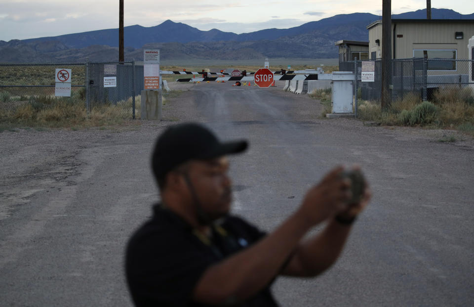 FILE - In this July 22, 2019, file photo, Terris Williams visits an entrance to the Nevada Test and Training Range near Area 51 outside of Rachel, Nev. Two men from the Netherlands who said they wanted to post internet video of the once-secret Area 51 military base in Nevada were arrested on suspicion of trespassing onto a secure U.S. government reservation, sheriff's officials said Thursday, Sept. 12, 2019. (AP Photo/John Locher, File)