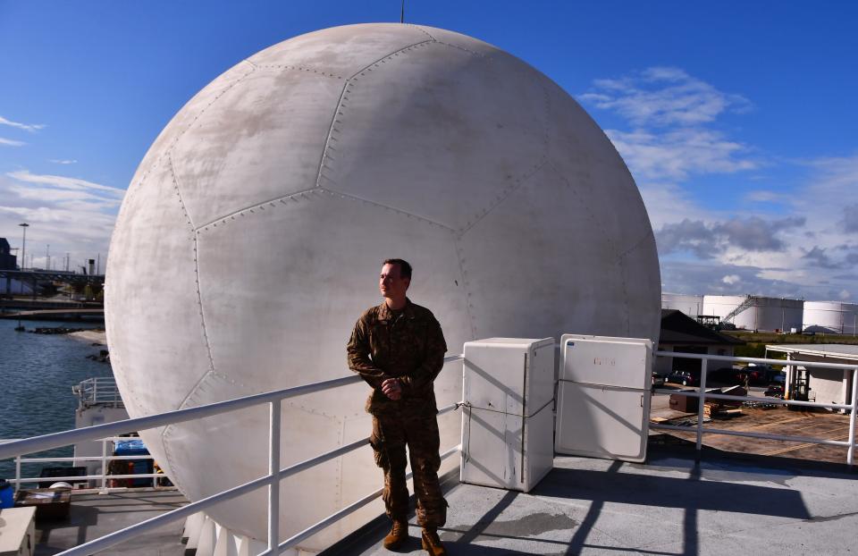 U.S. Air Force Capt. Richard Gayson stands by the Gray Star radar dome on the deck of the USNS Invincible at the U.S. Army Transportation Wharf at Cape Canaveral Space Force Station.