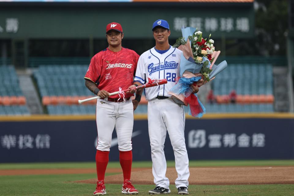 林智勝(左)代表味全龍送教練棒及一束花給高國輝。富邦悍將提供