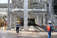 Workers are seen at the damaged site of Saudi Aramco oil facility in Khurais