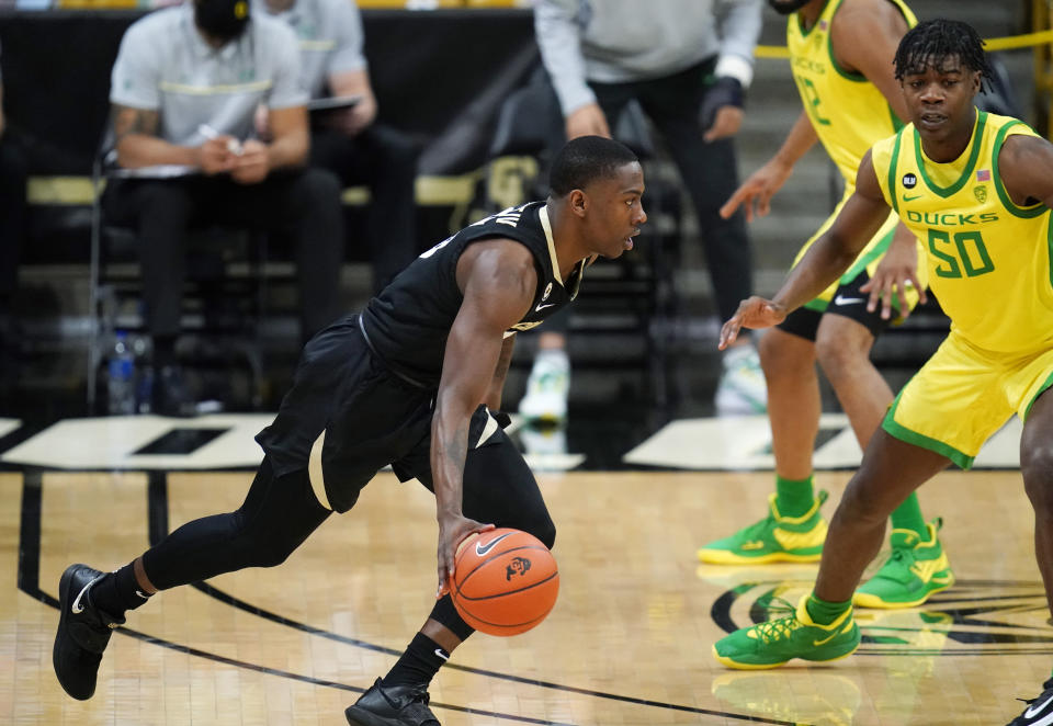 Colorado guard McKinley Wright IV, left, drives to the basket as Oregon forward Eric Williams Jr. defends in the first half of an NCAA college basketball game Thursday, Jan. 7, 2021, in Boulder, Colo. (AP Photo/David Zalubowski)