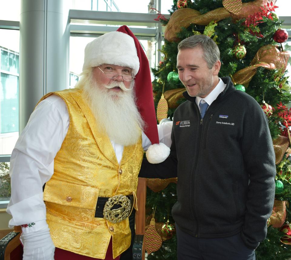 "Santa" Joe McGee greets Dr. Daniel Indelicato at the UF Health Proton Therapy Insttute's Christmas party for pediatric patients.