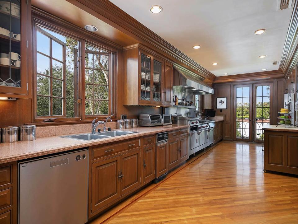 a long kitchen with windows and a glass door at the end