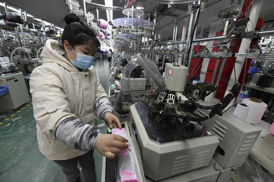 A worker operates a machine for knitting socks in a factory in Funan county in central China's Anhui province, Tuesday, March 1, 2022. China's ruling Communist Party is temporarily turning away from its longer-term ambitions to focus on pulling the economy out of a slump as the country heads into the annual meeting of its ceremonial legislature. (Chinatopix via AP)