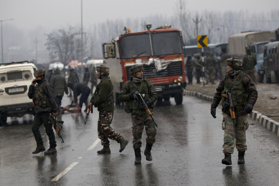 Indian paramilitary soldiers patrol at the site of an explosion in Pampore, Indian-controlled Kashmir, Thursday, Feb. 14, 2019. Security officials say at least 10 soldiers have been killed and 20 others wounded by a large explosion that struck a paramilitary convoy on a key highway on the outskirts of the disputed region's main city of Srinagar. (AP Photo/Dar Yasin)