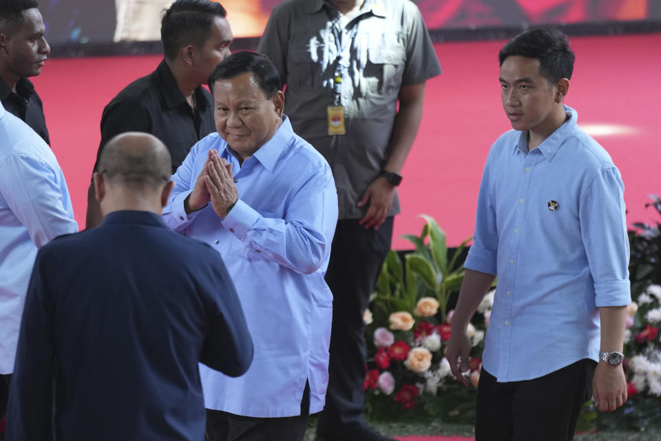 Presidential candidate Prabowo Subianto, left, greets the Chairman of the General Election Commission Hasyim Asyari as he walks with his running mate Gibran Rakabuming Raka, right, the eldest son of Indonesian President Joko Widodo, upon arrival to attend the "Declaration of Peaceful Election Campaign" at the General Election Commission Building in Jakarta, Indonesia, Monday, Nov. 27, 2023. Presidential candidates in the world's third-largest democracy will kick off their campaign period on Nov. 28 ahead of the country's simultaneous legislative and presidential elections in February 2024. (AP Photo/Tatan Syuflana)