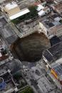 A sinkhole covers a street intersection in downtown Guatemala City, Wednesday, June 2, 2010. Authorities blamed heavy rains caused by tropical storm Agatha as the cause of the crater that swallowed a a three-story building but now say they will be conducting further studies to determine the cause. (AP Photo/Moises Castillo)