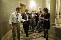 U.S. Senator Rand Paul (C) is flanked by reporters as he arrives for a Republican Senate caucus meeting at the U.S. Capitol in Washington, October 16, 2013. REUTERS/Jonathan Ernst
