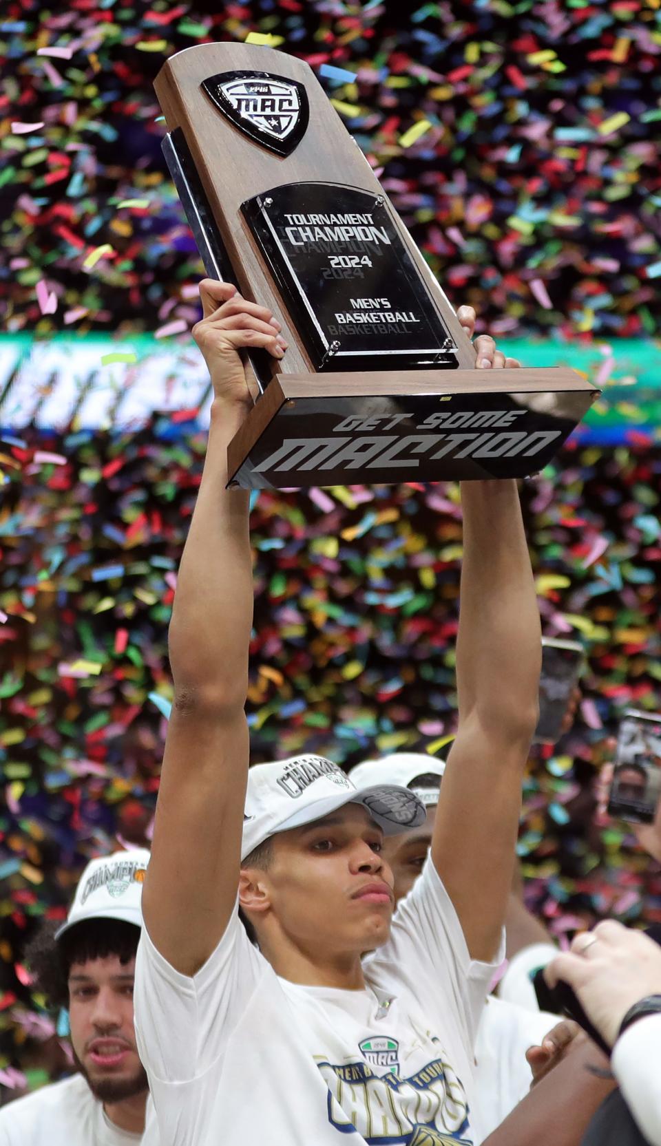 Akron Zips forward Enrique Freeman (25) holds up the championship trophy after beating Kent State, 62-61, in the Mid-American Conference Tournament championship game at Rocket Mortgage FieldHouse, Saturday, March 16, 2024, in Cleveland, Ohio.