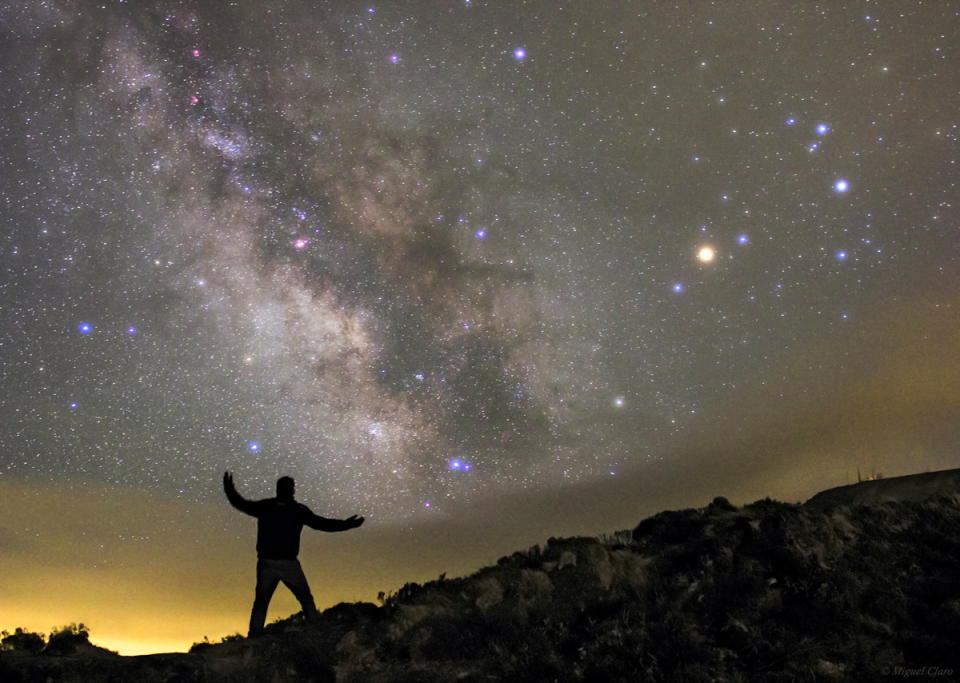Astrophotographer Miguel Claro sent a photo of a skywatcher in silhouette, appearing to hold up the night sky in the Azores, Portugal, on May 4, 2014. The constellation Sagittarius glows at the left, with Scorpius on the right.