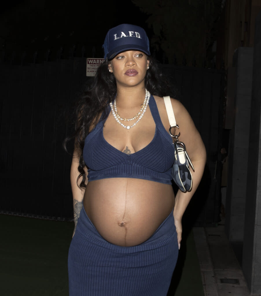 Rihanna shows off her huge baby bump while wearing denim and an LAFD hat at Nobu in West Hollywood