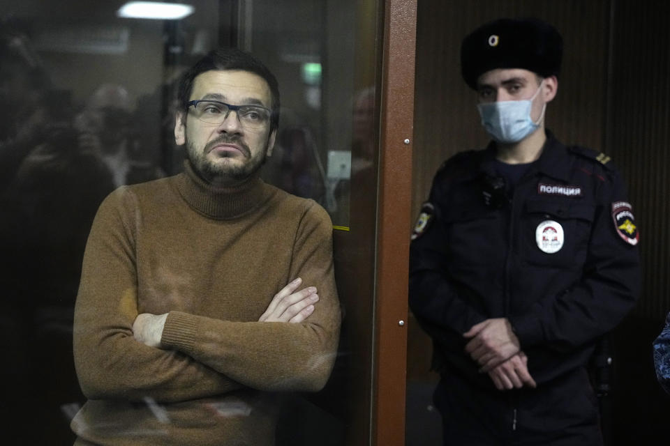 Russian opposition activist and former municipal deputy of the Krasnoselsky district Ilya Yashin stands in a cage in a courtroom prior to a hearing in Moscow, Russia, Tuesday, Nov. 29, 2022. Yashin, one of the few prominent opposition figures to have remained in the country amid an intensifying crackdown on dissent was arrested in June in a Moscow park and later was charged with spreading false information about the Russian military — a new criminal offense for which he faces up to 10 years in prison if convicted. (AP Photo/Alexander Zemlianichenko)