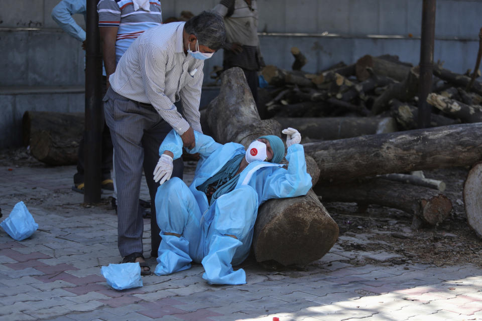 A relative of a person who died of COVID-19 breaks down during cremation in Jammu, India, Sunday, April 25, 2021. India’s crematoriums and burial grounds are being overwhelmed by the devastating new surge of infections tearing through the populous country with terrifying speed, depleting the supply of life-saving oxygen to critical levels and leaving patients to die while waiting in line to see doctors. (AP Photo/Channi Anand)