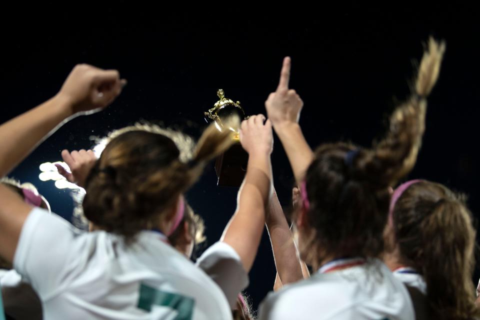 Dock Mennonite girls soccer team raises the trophy after the PIAA District One Class 1A championship game at Central Bucks West High School in Doylestown on Tuesday, Nov. 1, 2022. Dock Mennonite defeated last year's champion Faith Christian 2-1.