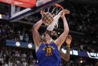 Denver Nuggets center Nikola Jokic (15) dunks against Los Angeles Lakers forward LeBron James, back, during the second half in Game 1 of an NBA basketball first-round playoff series Saturday, April 20, 2024, in Denver. (AP Photo/Jack Dempsey)