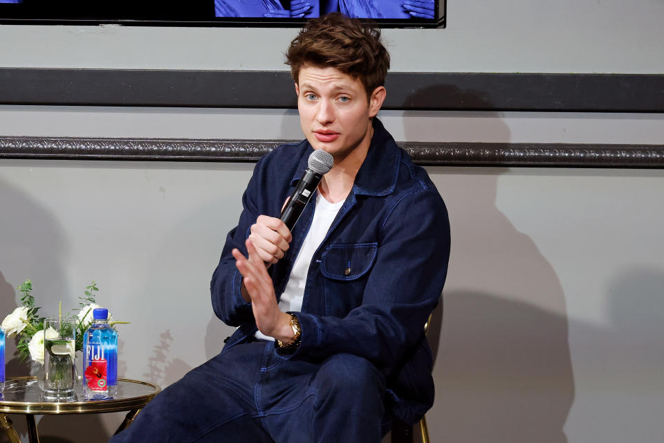 Matt Rife in a denim outfit sitting and speaking into a microphone at an event
