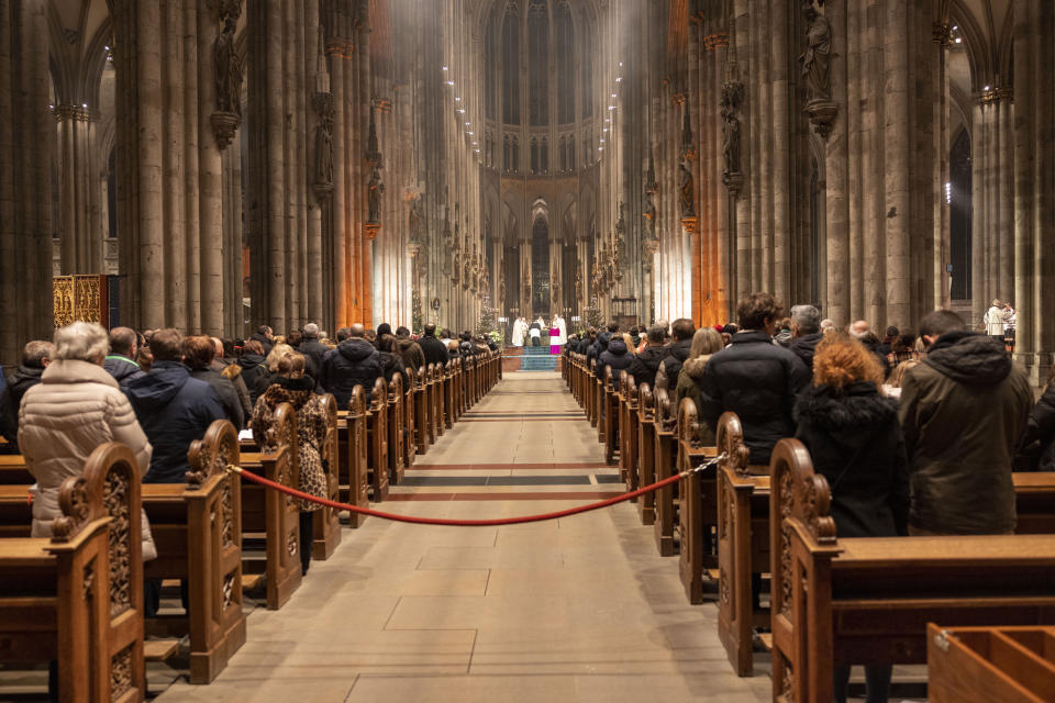 The faithful celebrate the end-of-year pontifical mass in the Cologne Cathedral, Cologne, Germany, Sunday, Dec. 31, 2023. German authorities say they have detained three more people in connection with a reported threat to Cologne Cathedral over the holiday period. (Thomas Banneyer/dpa via AP)