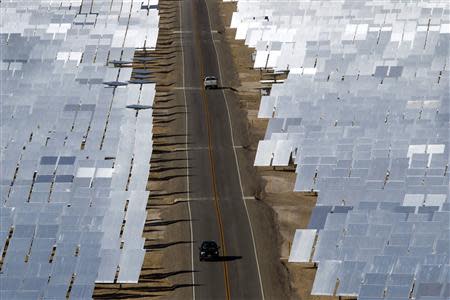Vehicles drive through field of heliostats (mirrors that track the sun and reflect the sunlight onto a central receiving point) at the Ivanpah Solar Electric Generating System in the Mojave Desert near the California-Nevada border February 13, 2014. REUTERS/Steve Marcus