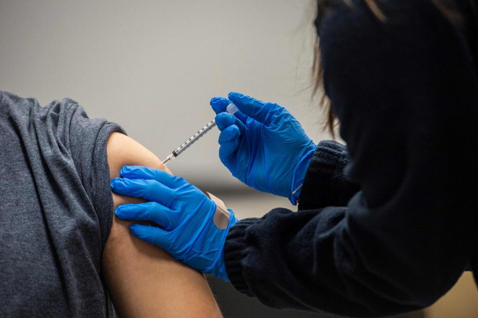 A man is inoculated with the Pfizer-BioNTech Covid-19 vaccine at La Colaborativa in Chelsea, Massachusetts on February 16, 2021.