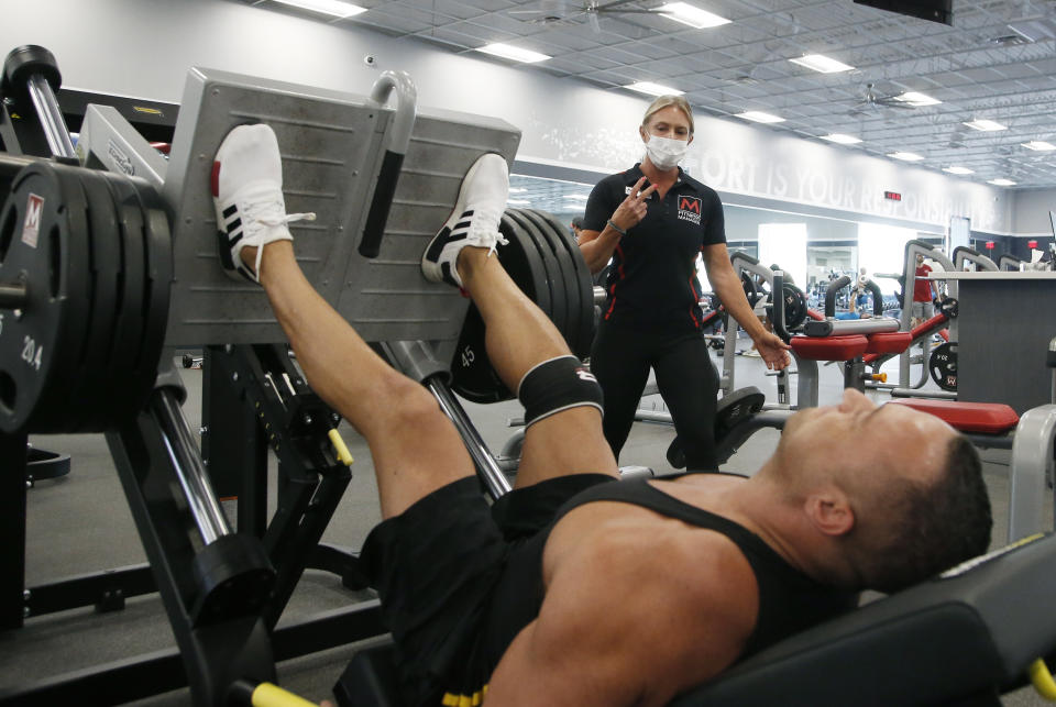 FILE - A trainer and club member at Mountainside Fitness, Thursday, July 2, 2020, in Phoenix, which has challenged Gov. Doug Ducey's gym shutdown order. A judge heard arguments Monday, Aug. 3, 2020, in the challenge filed by Mountainside Fitness and another health club chain. (AP Photo/Ross D. Franklin, File)