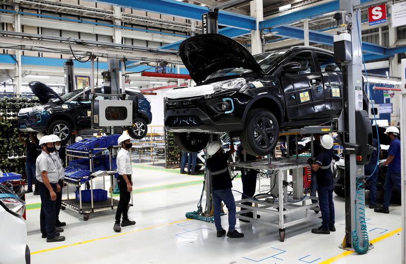FILE PHOTO: Workers inspect Tata Nexon electric sport utility vehicles (SUV) at a Tata Motors plant in Pune