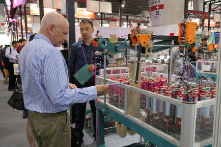 A visitor checks a spinning machine displayed at the China Import and Export Fair in Guangzhou, China April 17, 2017. REUTERS/Venus Wu