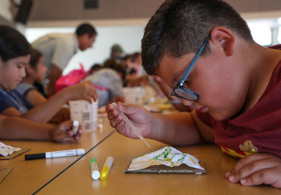 Las Palmitas third grader Carlos Corrales learns about watersheds by pouring small amounts of water on a crinkled-up piece of paper while Friends of the Desert Mountains held an environmental education program at the school in Thermal, Calif., May 9, 2023. 