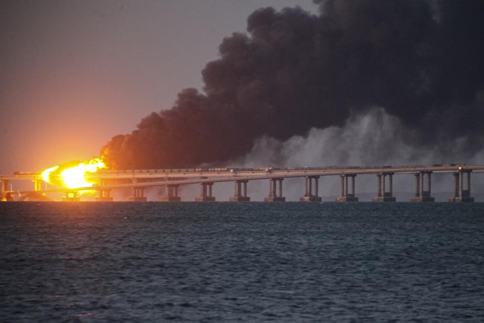 FILE - Flame and smoke rise from Crimean Bridge connecting Russian mainland and Crimean peninsula over the Kerch Strait, after what Russian authorities said was a bomb caused fire and partial collapse of the bridge, in Kerch, Crimea, Saturday, Oct. 8, 2022. A top Ukrainian official on Sunday, April 2, 2023, outlined a series of steps the government in Kyiv would take after the country reclaims control of Crimea, including dismantling the strategic bridge that links the seized Black Sea peninsula to Russia. (AP Photo, File)