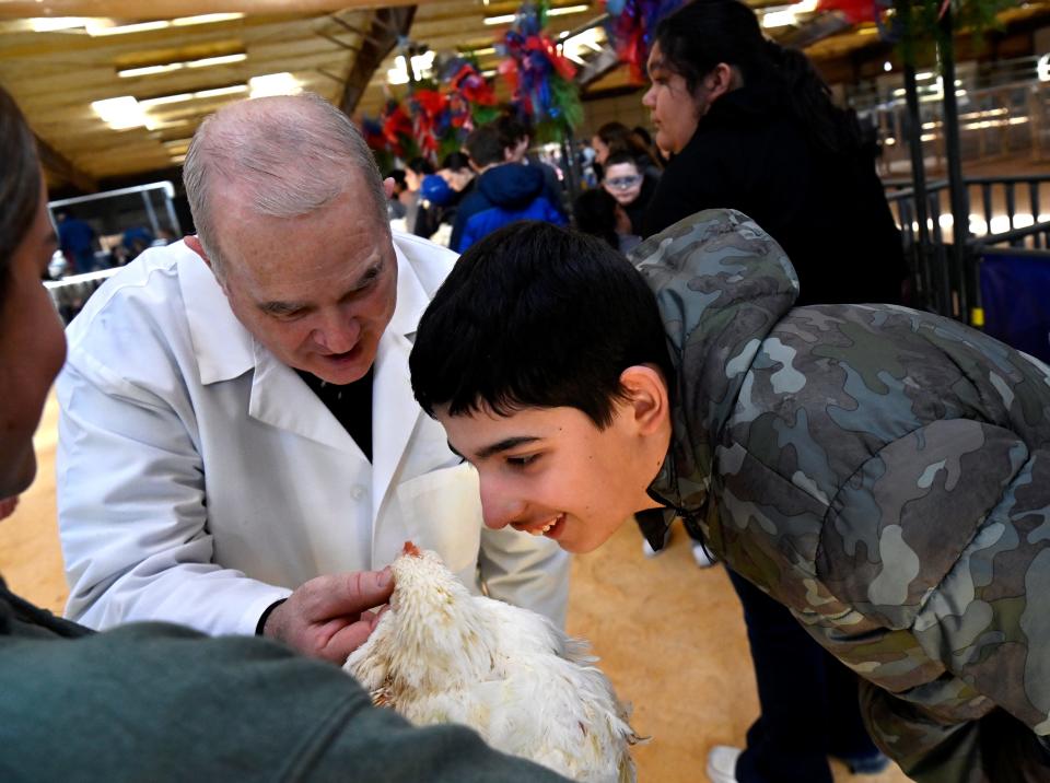 David Frazier holds a chicken’s beak as Austin Torres takes a closer look during the Scurry Stars event at the Scurry County Junior Livestock Show in Snyder Jan. 18.
