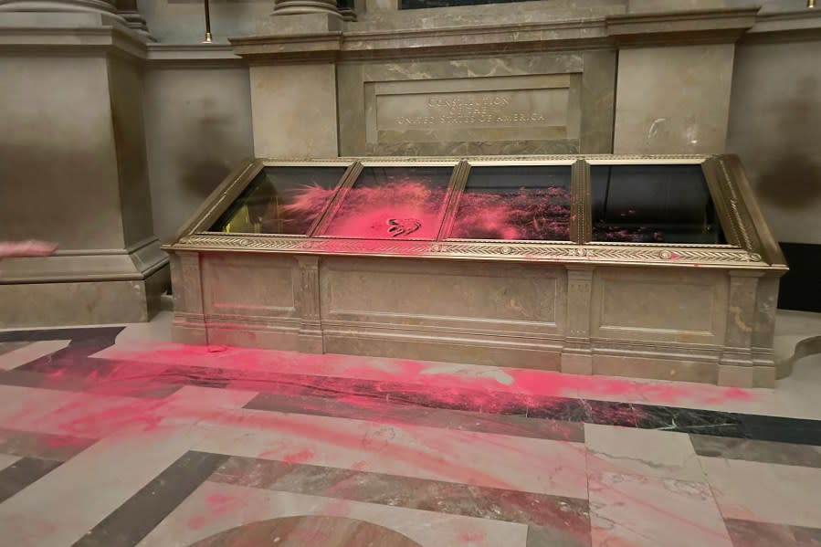 Pink powder is seen on the casement of the U.S. Constitution inside the National Archives Rotunda in Washington, Feb. 14, 2024. The National Archives building and galleries were evacuated after two protesters dumped powder on the protective casing around the U.S. Constitution. (Ellis Brachman/National Archives via AP)