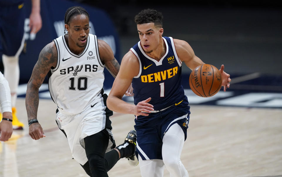Denver Nuggets forward Michael Porter Jr., right, collects the ball as San Antonio Spurs forward DeMar DeRozan defends in the second half of an NBA basketball game Friday, April 9, 2021, in Denver. (AP Photo/David Zalubowski)