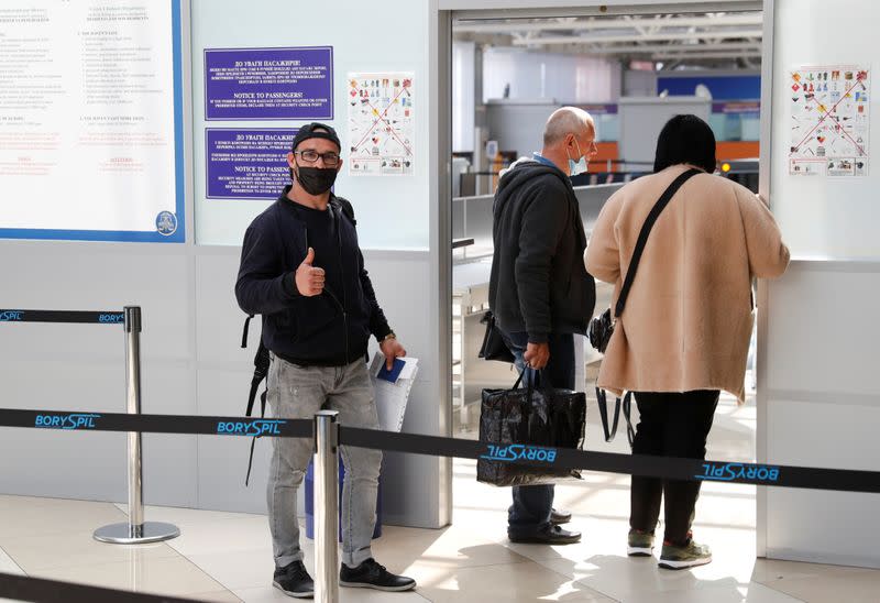 Ukrainian worker Diachenko poses for a picture before his departure at an airport outside Kiev