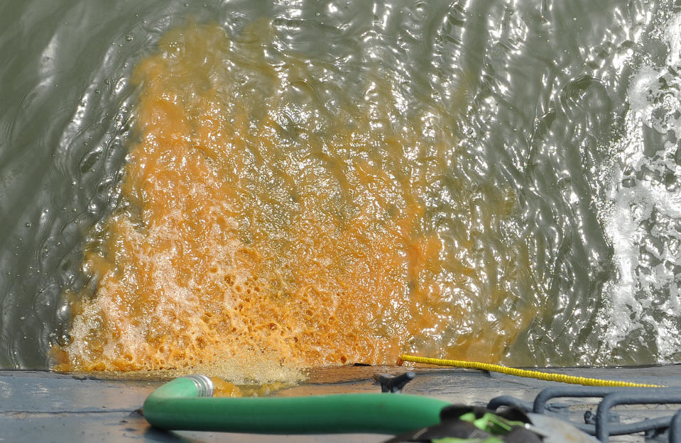 Rusty water is pumped from a tank on the USS Texas Wednesday, June 13, 2012, in Houston. The 100-year-old battleship's hull sprung a leak five days ago and has been taking on as much as 1,000 gallons of seawater every minute as workers struggle to contain it. (AP Photo/Pat Sullivan)