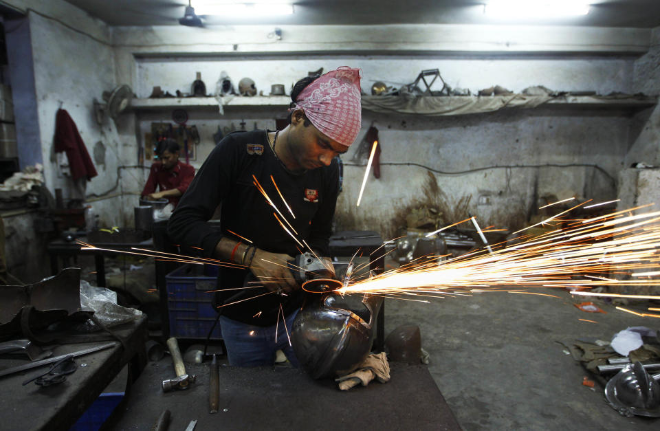 In this, June 2, 2012 photograph, a laborer works on a helmet being prepared for a Hollywood period movie at a workshop owned by Indian businessman Ashok Rai, unseen, in Sahibabad, India. From Hollywood war movies to Japanese Samurai films to battle re-enactments across Europe, Rai is one of the world's go-to men for historic weapons and battle attire. (AP Photo/Saurabh Das)