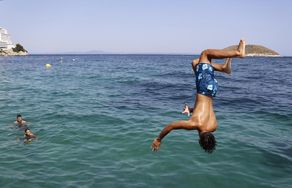 A boy jumps into the sea from the rocks of Magaluf beach on July 30 in Mallorca, Spain. The area is a popular tourist destination, particularly for British travelers. (Photo: Clara Margais via Getty Images)