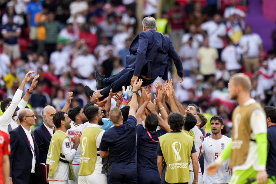 Players throw Iran&#39;s head coach Carlos Queiroz in air as they celebrate after their win in the World Cup group B soccer match between Wales and Iran, at the Ahmad Bin Ali Stadium in Al Rayyan, Qatar, Friday, Nov. 25, 2022. (AP Photo/Alessandra Tarantino)