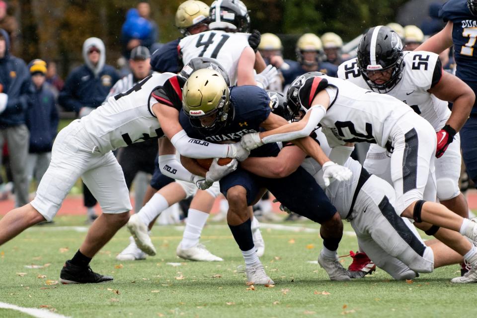 Penn Charter running back Chandler Turner is taken down by Germantown Academy defensemen Seamus Knox, left, Donny Lattanze, back, and Anthony Lara during the 135th annual rivalry game in Philadelphia on Saturday, November 13, 2021. The Quakers defeated the Patriots 35-32.