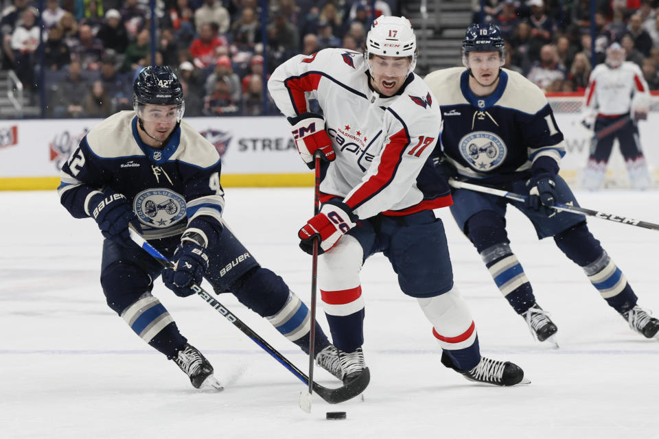 Washington Capitals' Dylan Strome, front right, carries the puck across the blue line against Columbus Blue Jackets' Alexandre Texier, left, during the first period of an NHL hockey game Thursday, Dec. 21, 2023, in Columbus, Ohio. (AP Photo/Jay LaPrete)