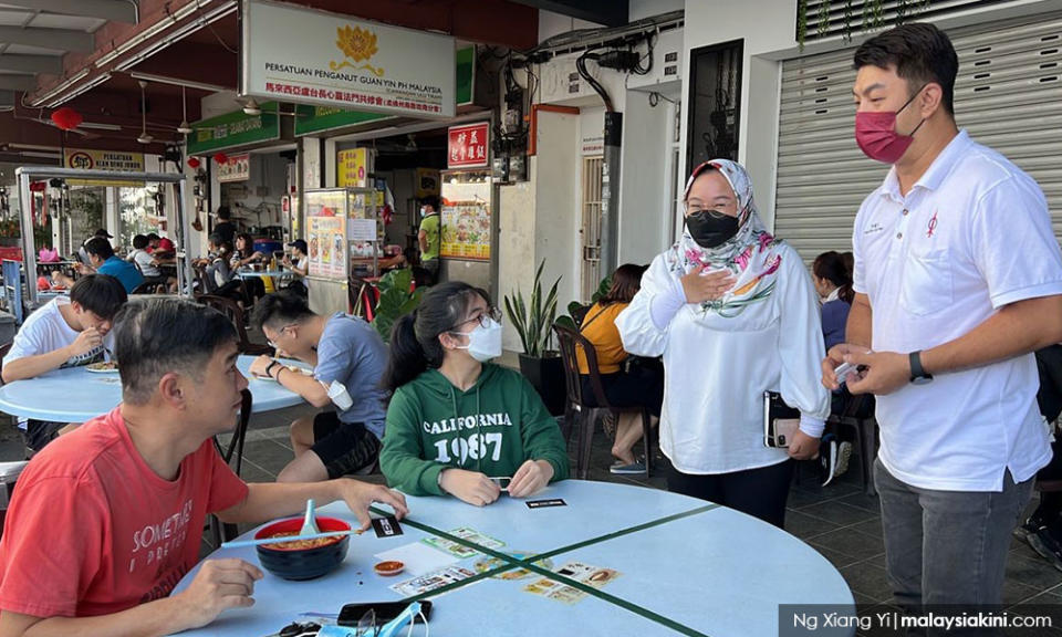 Former DAP Yong Peng district councillor Koh Chia Heng (right) assists Muda’s Puteri Wangsa candidate Amira Aisya to campaign in Taman Pelangi Indah