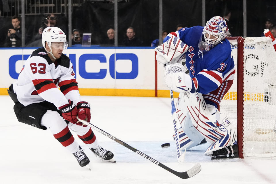 New York Rangers goaltender Igor Shesterkin (31) passes the puck away from New Jersey Devils' Jesper Bratt (63) during the first period of Game 4 of an NHL hockey Stanley Cup first-round playoff series Monday, April 24, 2023, in New York. (AP Photo/Frank Franklin II)