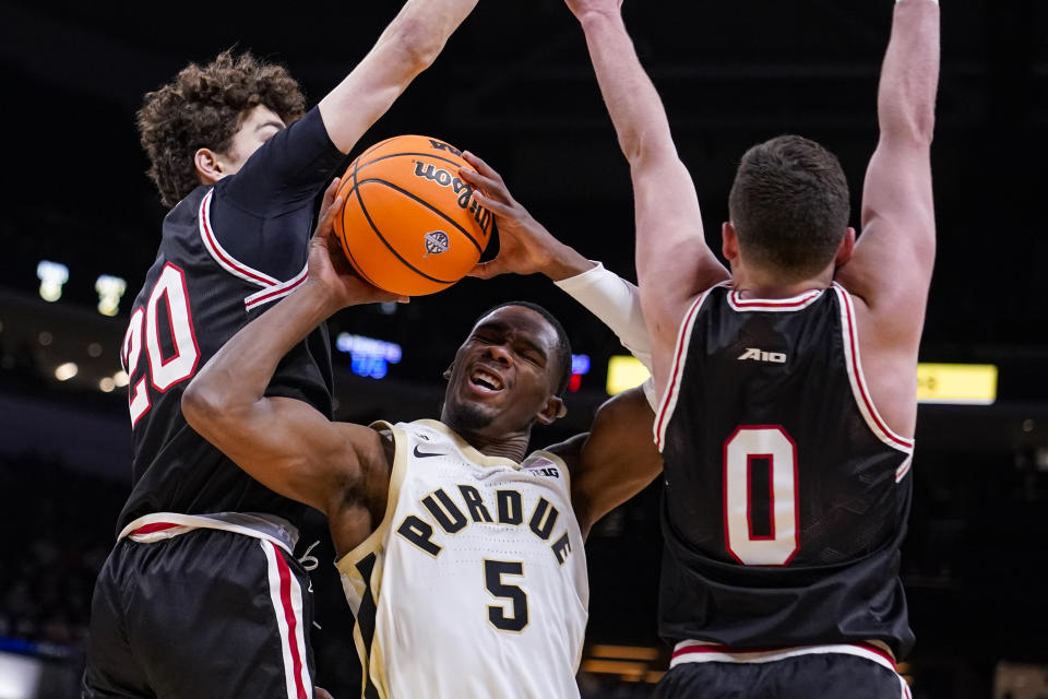 Purdue guard Brandon Newman (5) shoots between Davidson guard Achile Spadone (20) and guard Foster Loyer (0) in the first half of an NCAA college basketball game in Indianapolis, Saturday, Dec. 17, 2022. (AP Photo/Michael Conroy)