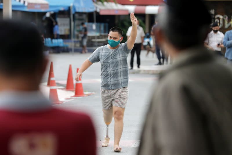 Nutchanon Pairoj flashes a three-finger salute outside a prison in Pathum Thani province