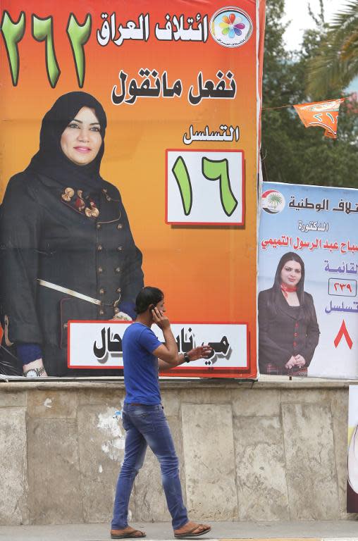 A man walks past an election campaign banner showing candidate May Nayef al-Rahal in the capital Baghdad, on April 15, 2014