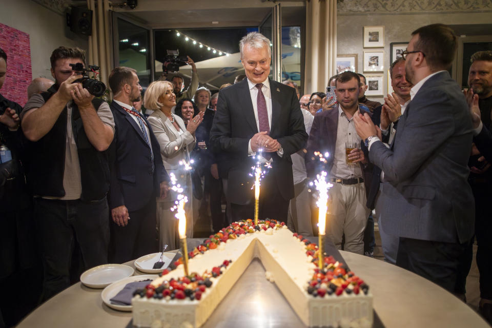 Lithuania's President Gitanas Nauseda, a presidential candidate, center, celebrates winning the second round of Lithuania's presidential election, in Vilnius, Lithuania, late Sunday, May 26, 2024. (AP Photo/Mindaugas Kulbis)