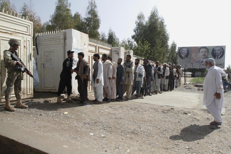 Afghan men line up for registration process before casting their votes at a polling station in Kandahar, Afghanistan, Saturday, April 5, 2014. Afghan voters lined up for blocks at polling stations nationwide on Saturday, defying a threat of violence by the Taliban to cast ballots in what promises to be the nation's first democratic transfer of power. (AP Photo/Allauddin Khan)