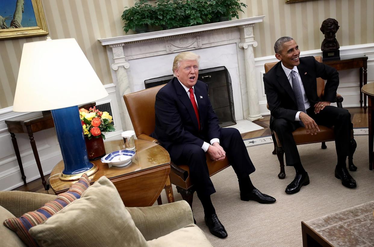 Donald Trump and Barack Obama enjoy a light-hearted exchange with journalists in the White House in December: Getty