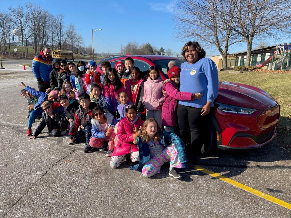 A group of kids in front of a car