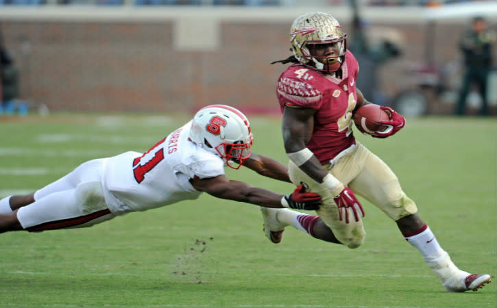 Nov 14, 2015; Tallahassee, FL, USA; Florida State Seminoles running back Dalvin Cook (4) runs the ball past North Carolina State Wolfpack cornerback Juston Burris (11) during the second half of the game at Doak Campbell Stadium. Mandatory Credit: Melina Vastola-USA TODAY Sports