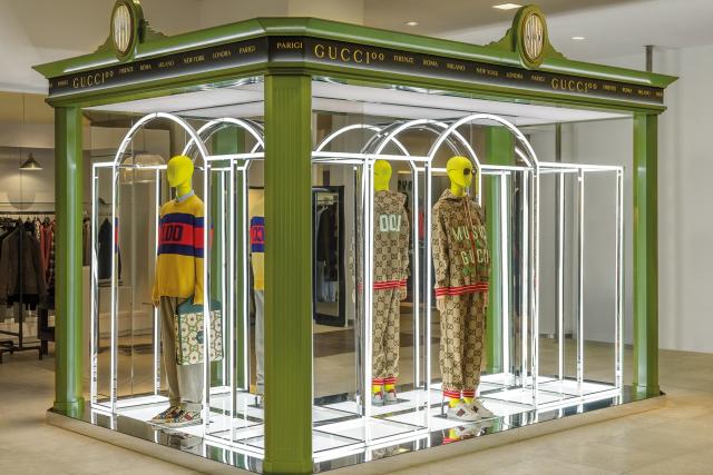 People shop in the Gucci department at a Saks Fifth Avenue store